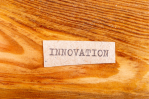 Card with the word INNOVATION on a wooden surface, suggesting creative thinking or new ideas.